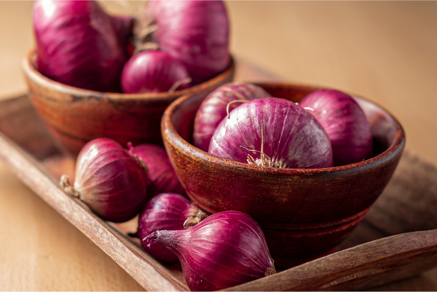 Wooden platter of red onions